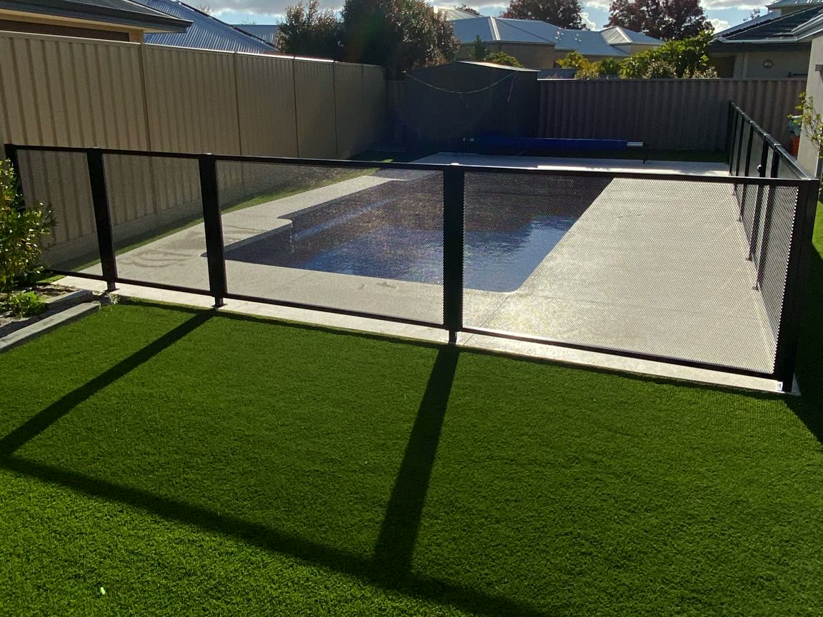 Black PerfMesh pool fencing beside a lap pool, Perth